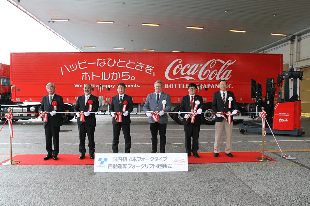 起動式でテープカットを行う両社関係者